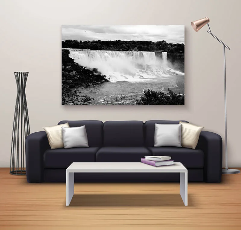 Black and white niagara falls canvas above a dark grey sofa with a wide coffee table and tall lamp