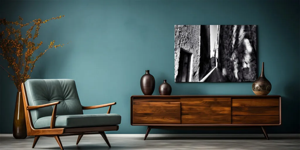 Black and White Mdina alley canvas above a wooden sidetable with blue green wall and an blue green armchair