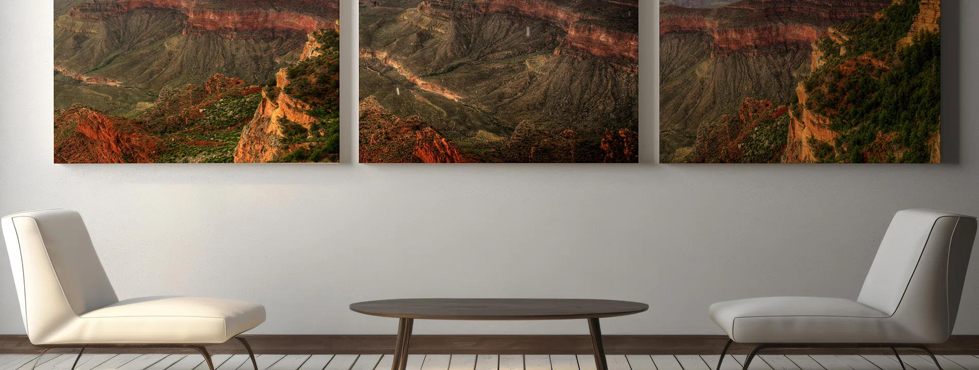 three hanged canvas prints with landscape photos of the grand canyon hanged on a wall above 2 arm chairs and a coffee table