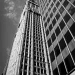 A tall office building in New York City in black and white