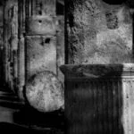 Roman remains including an arch and columns at Pompeii in monochrome