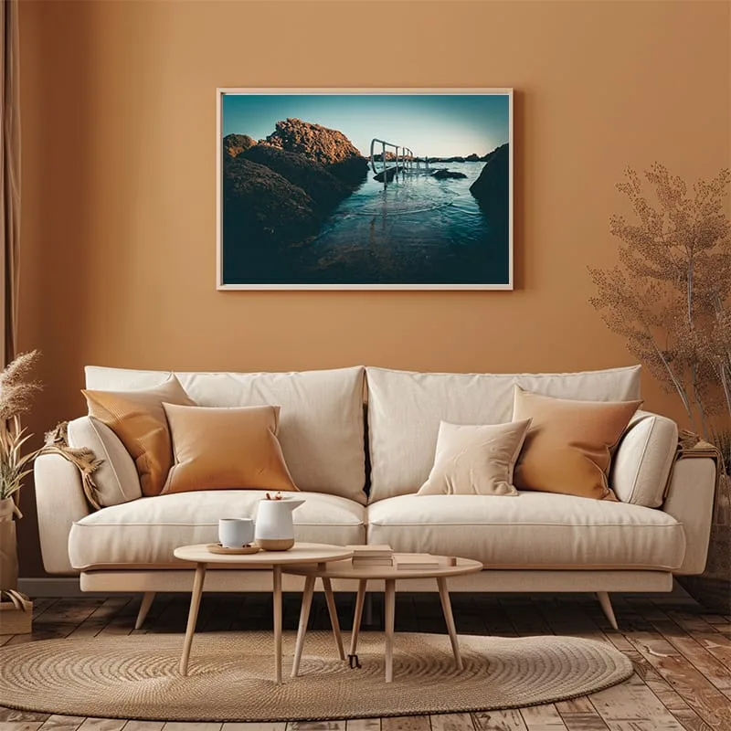 Ghar Lapsi slipway framed photo above a white sofa, yellow pillow and yellow wall