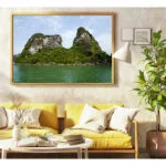 Rock Formations in Halong Bay Vietnam frame hang above 2 yellow arm chairs with a coffee table and some books