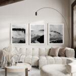 3 photo frames of Niagara falls in black and white hanged above a white sofa in a living room