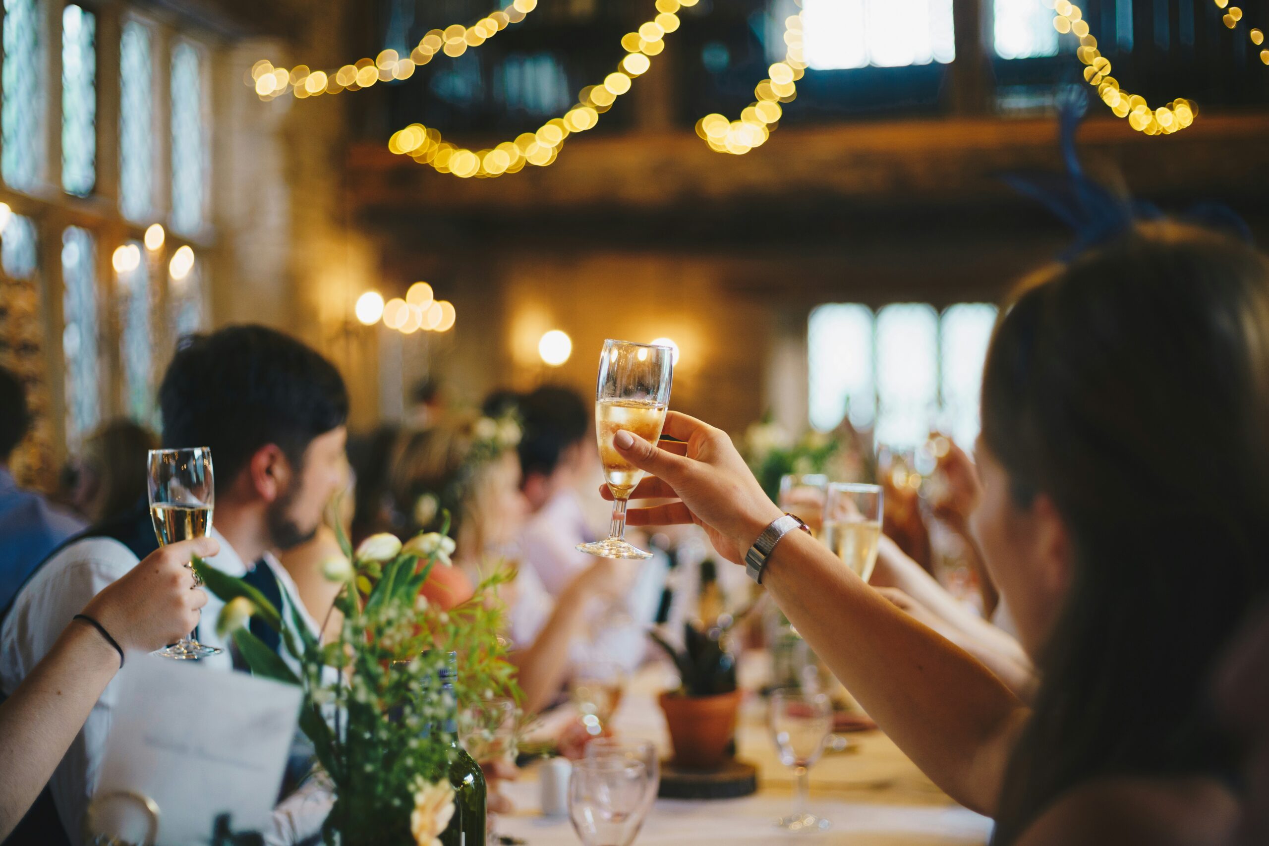 A group of guests joyfully toasting with glasses at a wedding reception, celebrating love and togetherness.