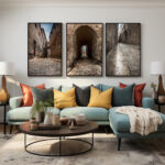 A stylish living room showcasing a blue couch and two framed images depicting the timeless streets of Mdina.