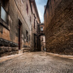 A charming street scene in Mdina, with a historic building rising in the background, reflecting the city's enduring beauty.