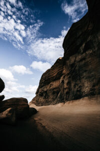 A rugged, rocky canyon under a blue sky with scattered clouds at Gozo Qbajjar