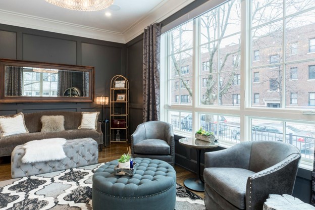 A modern living room featuring gray walls and a sleek black couch, creating a stylish and contemporary atmosphere.