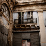 An old building in Valletta featuring a balcony and a door, showcasing classic architectural elements.