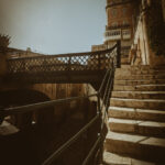 A historic iron bridge and weathered stone staircase in Valletta, Malta, bathed in warm sunlight, evoking a sense of nostalgia and timeless beauty.