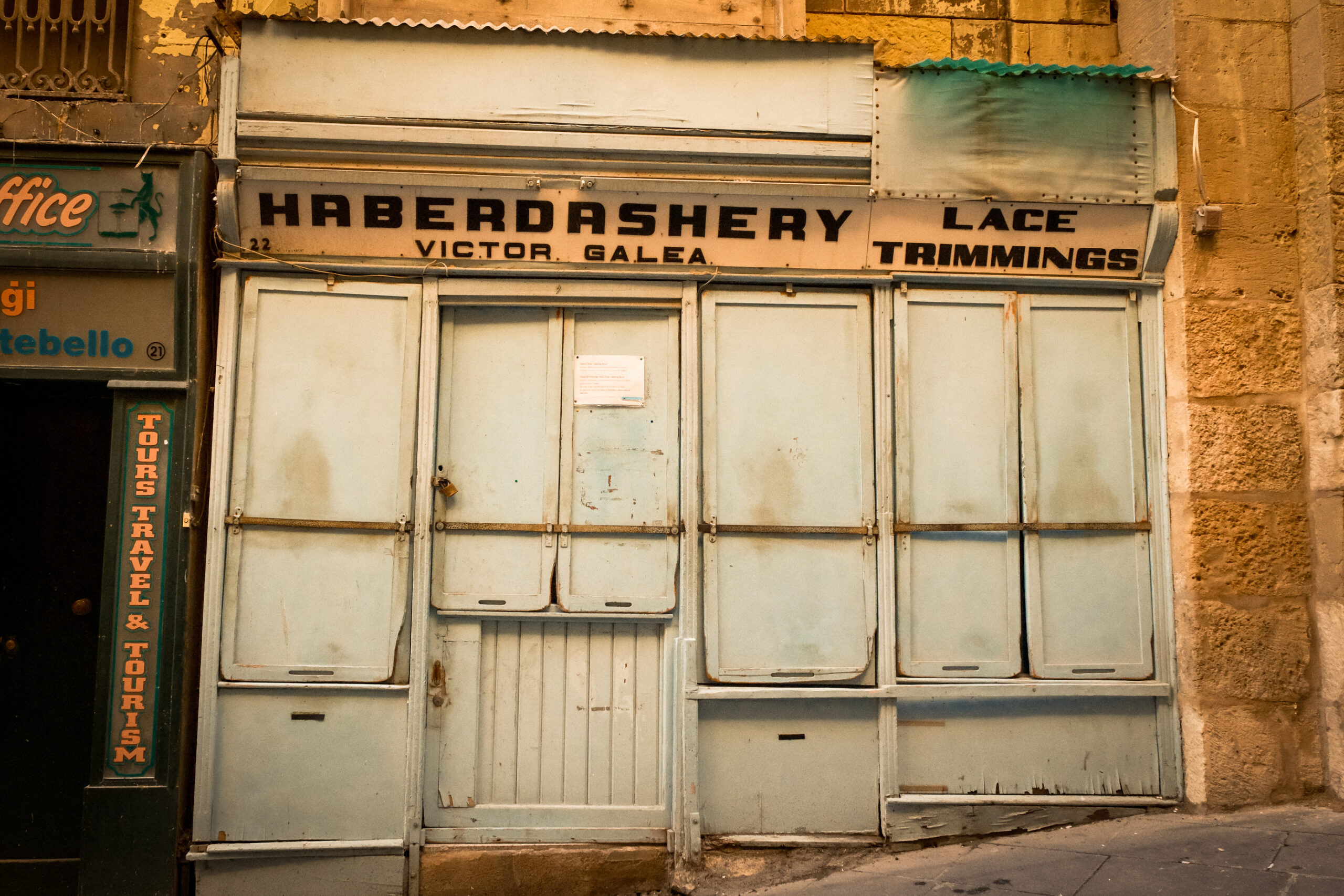 A historic haberdashery shop in Valletta, showcasing a blue door and a sign that reads "haberdashery"