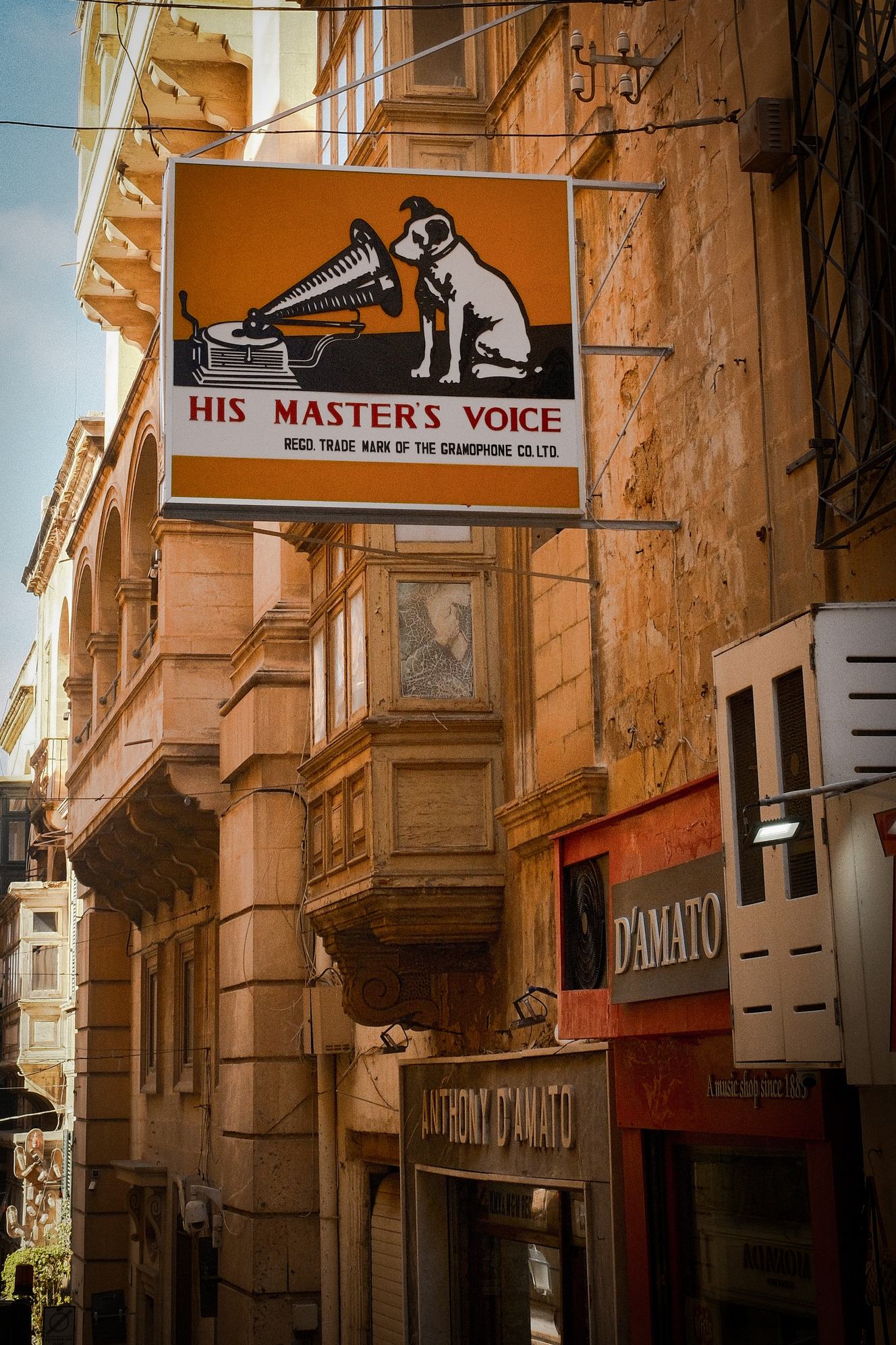 A notable sign for D'Amato Records, elegantly positioned on a building in Valletta, highlighting the shop's character.