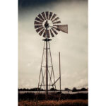 Windmill in Malta standing over yellow fields under a cloudy sky, symbolising rural Maltese agriculture