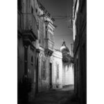 Street view in Rabat leading to a distant church dome.