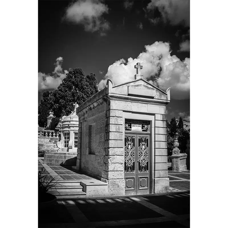 Historic cemetery chapel with cross and wrought iron door in Rabat.