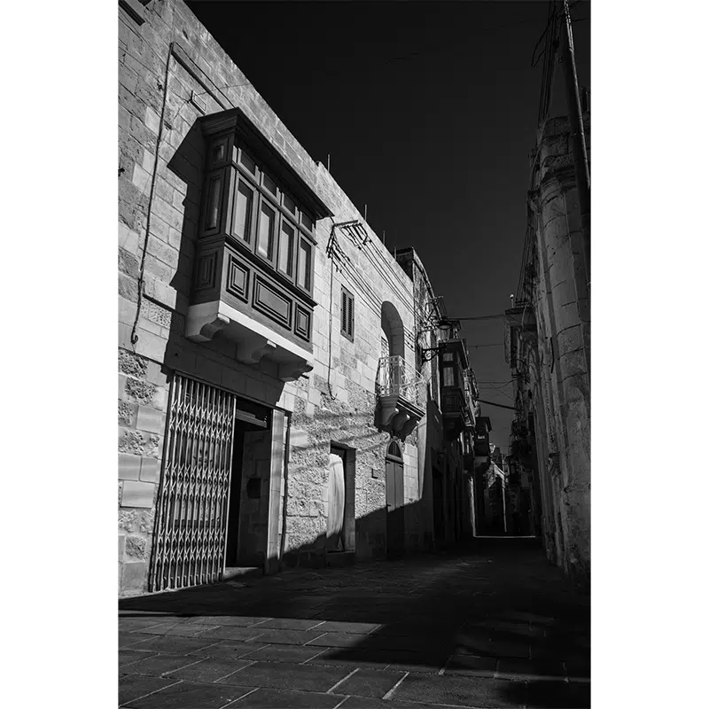 Narrow street in Rabat lined with stone houses and traditional balconies.