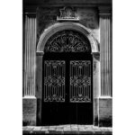 Ornate wrought iron door framed by classical columns in Rabat, Malta.