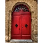 Red traditional Maltese door in stone archway in Mdina