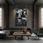 A modern, minimalist living room with a large window looking out onto a cityscape. A person is sitting on a sofa, reading a book. The "Gozo Qbajjar Battery Monochrome - Wall Art" is hanging on the wall above the sofa, adding a touch of sophistication to the space.