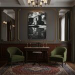 A monochrome print of the Gozo Qbajjar Battery mounted on a wall above a modern, minimalist sofa in a light-filled living room, with a potted plant on a side table.