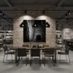 A large, framed print of the Mgarr Malta Church Arch hangs above a modern sofa in a brightly lit living room, with a decorative vase and books on a coffee table in the foreground.