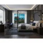 A person gazes at the majestic Fungus Rock in Gozo, Malta during blue hour, with the Dwejra Bay in the background. The sky is a deep indigo, reflecting in the calm waters.