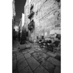 Black and white narrow stone alley with bicycle