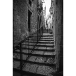 Narrow stone alley with steep steps and railing