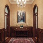 Elegant hallway with chandelier, console table, and artwork