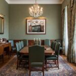 Elegant dining room with chandelier and green chairs