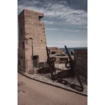 Rusted anchors beside coastal concrete fort tower