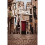 Red post box on narrow cobblestone street