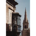 Historic stone balcony with church steeple backdrop