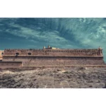 Historic stone fortress wall under dramatic sky