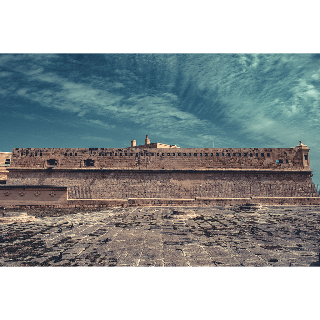 Historic stone fortress wall under dramatic sky