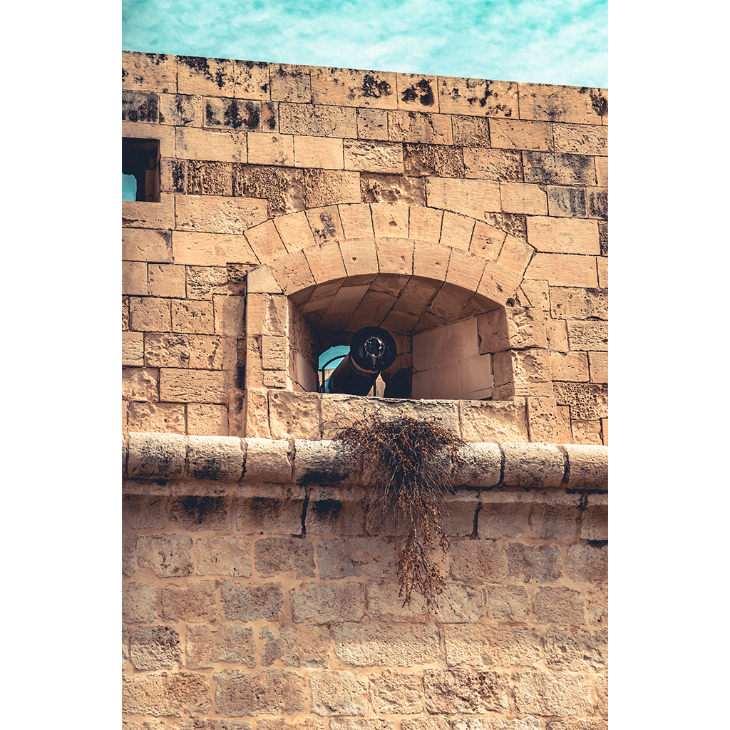 Historic stone fortress with cannon in arched window