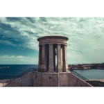 Stone coastal monument overlooking blue sea