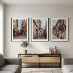 Three framed European street photos above modern console