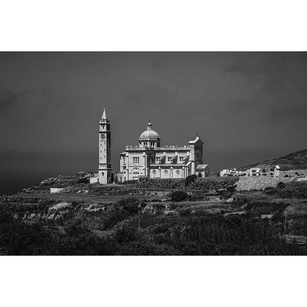 Black and white coastal church with tall bell tower