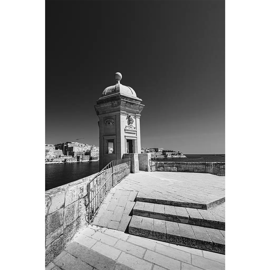 Stone watchtower overlooking harbor in black and white