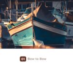 Two turquoise boats moored bow to bow at sunset