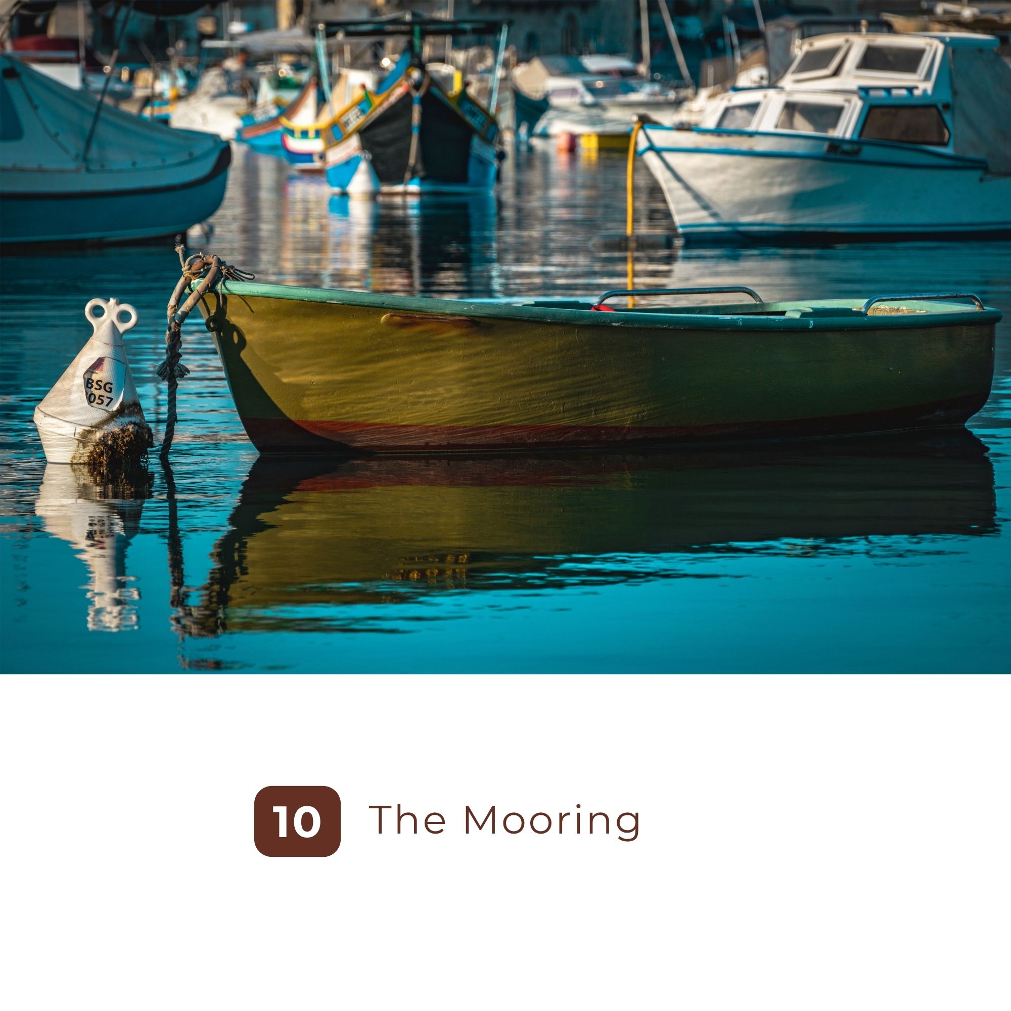 Green rowboat moored among fishing boats in calm harbor