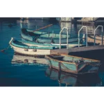 Weathered rowboats moored beside a dock on calm water