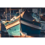 Two turquoise fishing boats moored at sunset