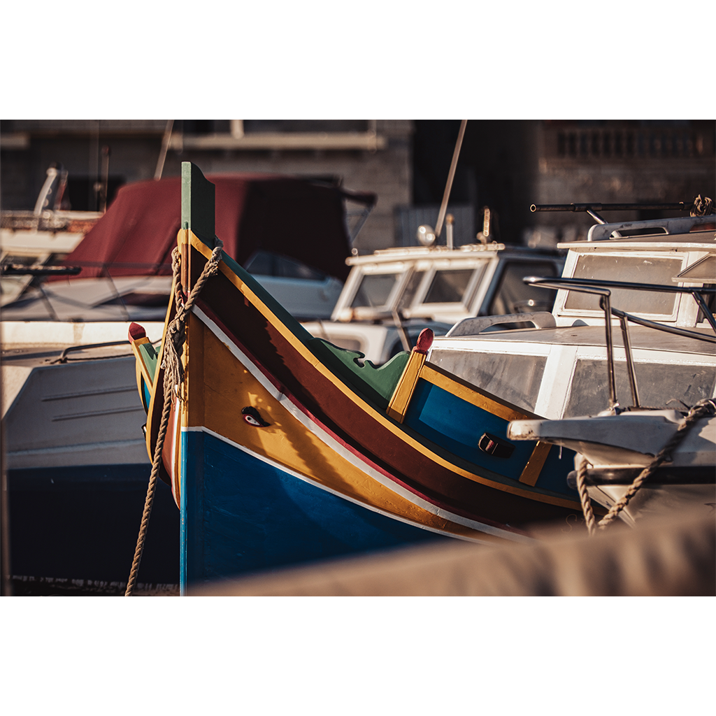Colorful traditional fishing boat moored among white motorboats