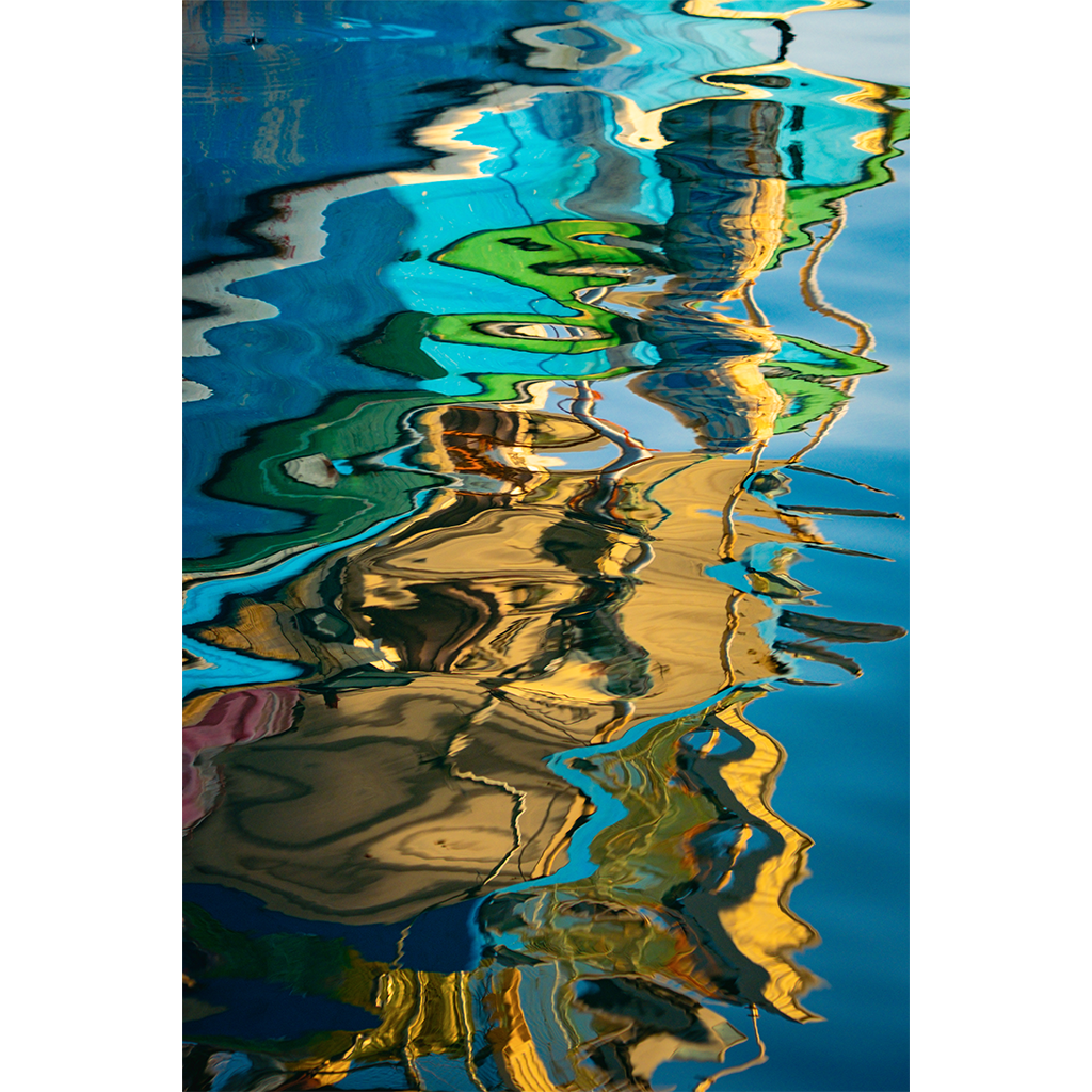 Colorful boats reflected in rippling blue water
