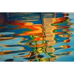 Colorful boats reflected in rippling blue water