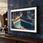 Framed turquoise boat photograph on dark marble wall