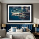 Framed boats artwork above elegant blue velvet bed
